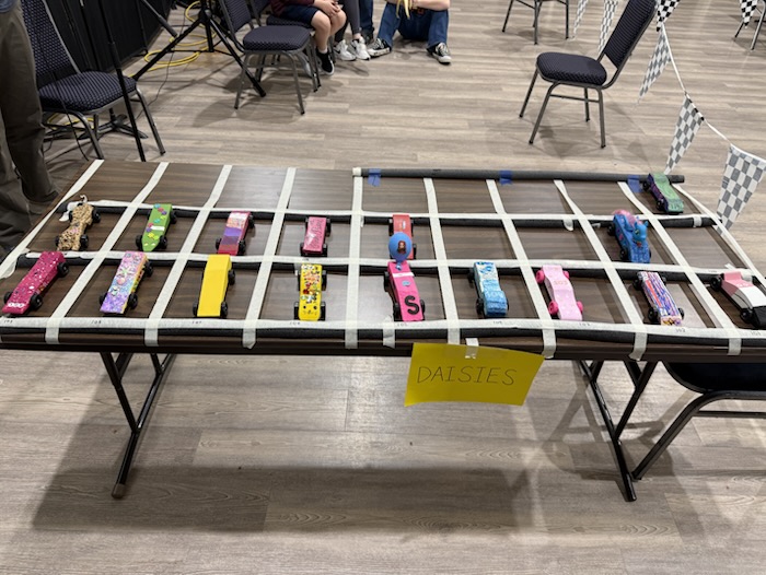 Colorful derby cars waiting in their numbered spaces.